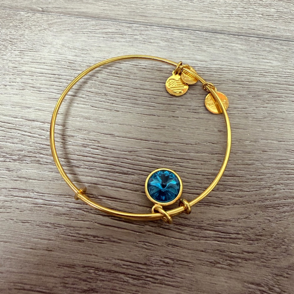 Goldβ Tone Bangle Bracelet with Blue Charm